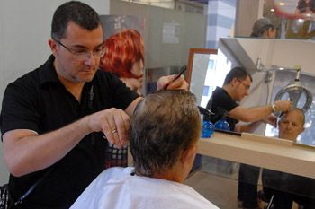 Cabeleireiro cortanto o cabelo de um cliente