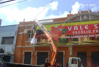 Fiscais da SEDEC retirando placa da fachada da Strauch