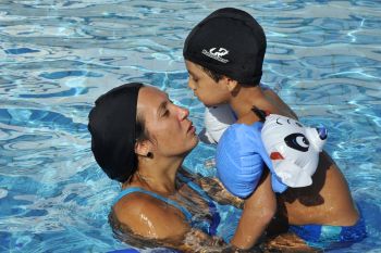 Mães acompanham seus filhos em aula de natação no Tancredão
