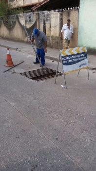 Operário faz a desobstrução manual e reparo na rede de drenagem na Rua Orlando Bonfim, no Bairro Caratoira