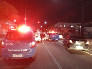 imagem mostra vários carros da Guarda Municipal cercando carro roubado