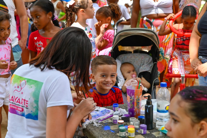 Crianças de divertem com pinturas de desenhos na pele.